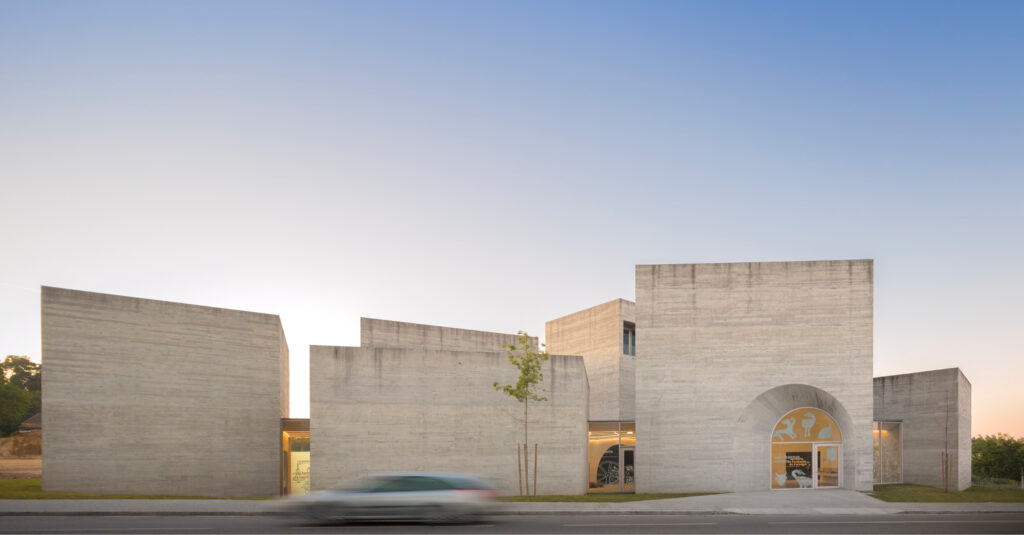 Street view of the Interpretation Centre of Romanesque in Lousada at dusk, a cluster of concrete volumes of different heights