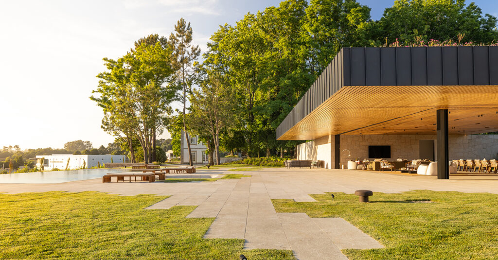 Summer Pavilion of Quinta das Águas in Famalicão, its dark-edged roof cantilevered over the lawn among trees