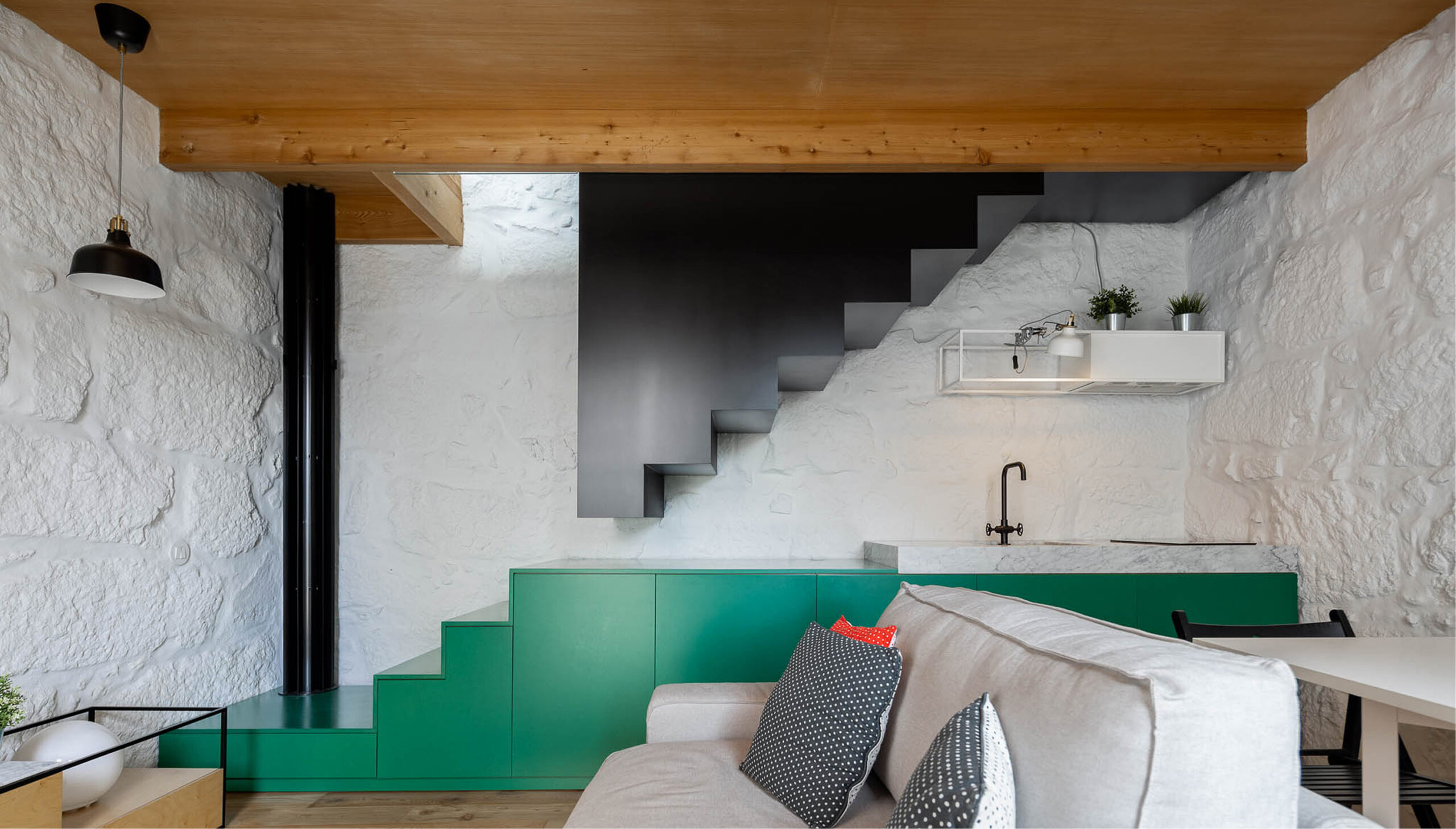 Covelo House, Porto: open living space where the green counter steps up into the black staircase