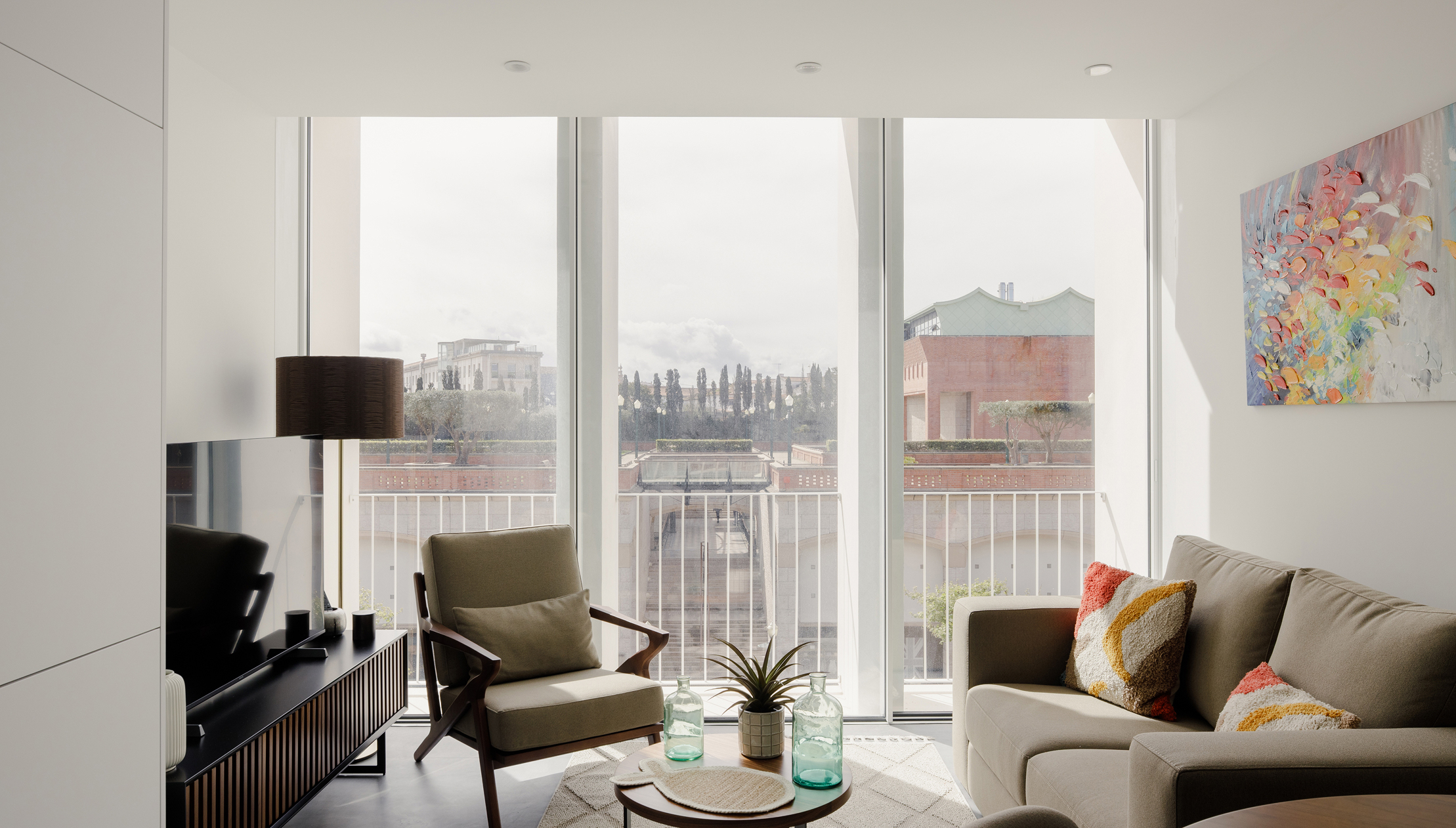 White Aveiro: apartment living room with armchair and sofa before full-height windows over the city
