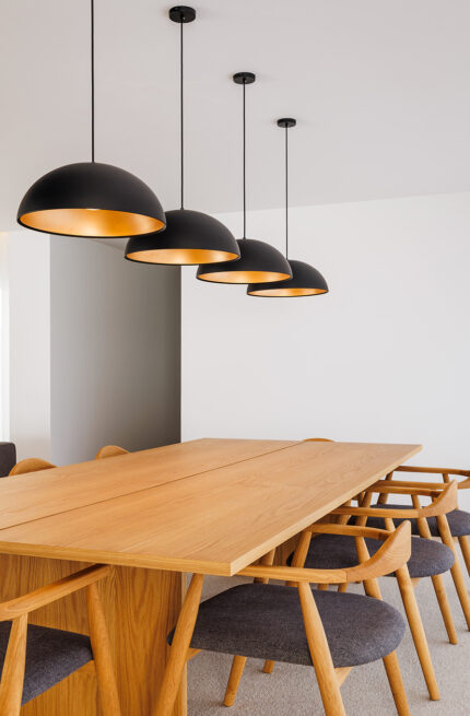 FS House, Paços de Ferreira: dining table in solid wood under a row of black pendant lamps