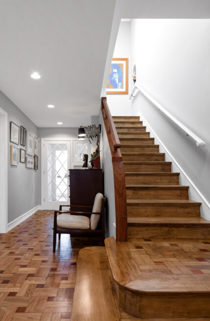 Combatentes House, Porto: entrance hall with a wooden staircase and parquet floor between grey walls