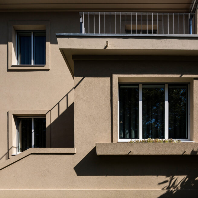 Combatentes House, Porto: close-up of the rendered facade with balcony and recessed windows