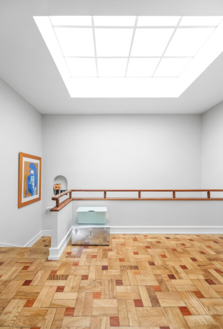 Combatentes House, Porto: upper landing under a large skylight, patterned parquet and a wooden handrail