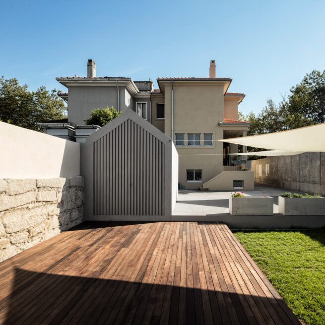 Combatentes House, Porto: wooden deck and lawn in the backyard, the annex and the rear facade behind